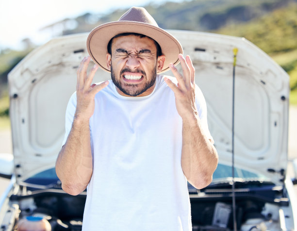 这张照片拍摄的是一个英俊的年轻人在遭遇汽车故障后站在路边图片下载