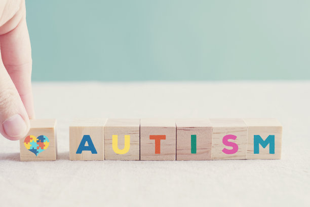 手握木块，用单词自闭症，世界自闭症意识日的概念图片下载