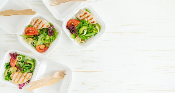 白色木桌上放着装有沙拉和鸡肉的午餐盒。外卖食物。本空间图片下载