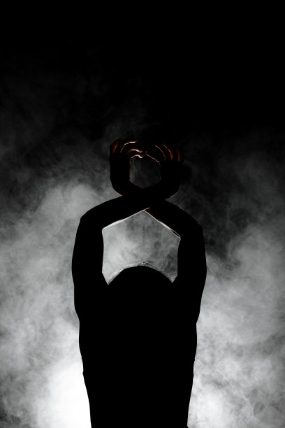 剪影现代芭蕾舞演员摆姿势在黑暗的背景与烟图片下载