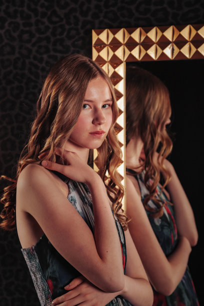 肖像的漂亮可爱的少女在一个优雅的裙子在镜子图片下载