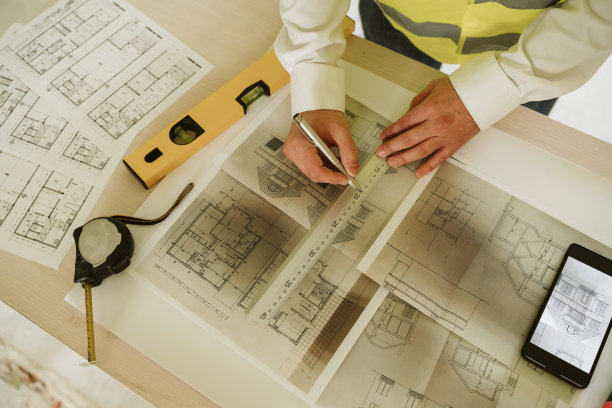 工头或不知名的建筑师在建筑工地设计图纸。家居装饰图片下载