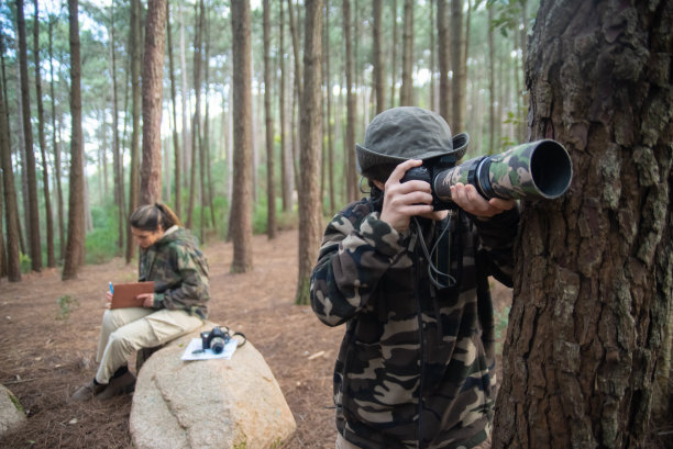 全神贯注的男孩带着相机在森林里图片下载