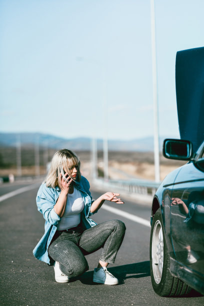 困惑的女性在路上打电话求助，因为车轮故障图片下载