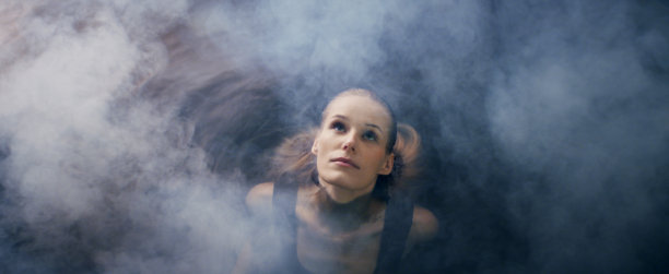 一个娇弱的女人从被雾覆盖的深色水中浮现出来。自然美容护理隐喻图片下载