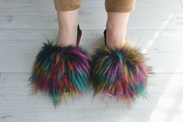 在卧室的木地板上，成年女人的腿和柔软的彩色拖鞋图片下载