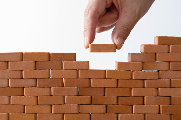 一个人把玩具砖贴在墙上图片下载