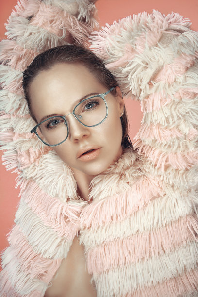 一个美丽的女模特的肖像，湿的头发，穿着条纹的粉红色毛皮大衣和光滑的眼镜图片下载