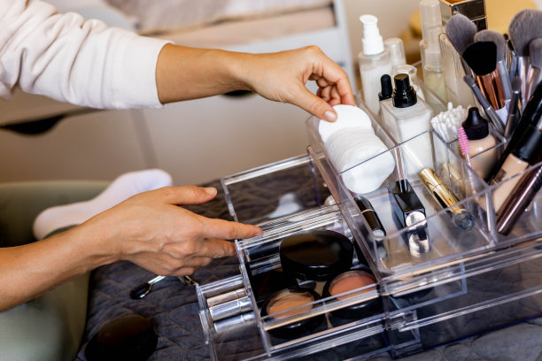 特写女性的手把豪华化妆品放进丙烯酸盒与抽屉存储组织图片下载