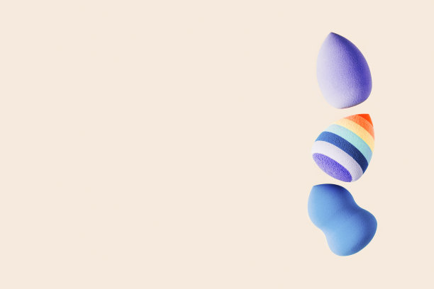 化妆海绵是蓝色和亮条纹的。柔软化妆海绵美容搅拌器，脸部化妆刷，面部涂抹器。背景为沙龙时尚美容化妆。关闭泡芙图片下载