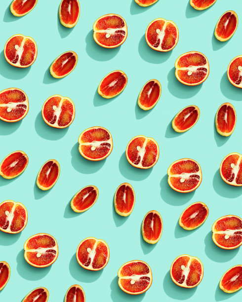 橘红色的水果带来夏季的食物模式，柑橘片与硬阴影在阳光下的薄荷背景。健康水果食品理念。平躺与多汁的红橙，创造性的布局图片下载