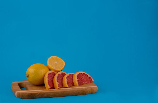 在照片中，切好的水果、刀和切菜板:橙子、橘子、柠檬、酸橙、柚子。新鲜柑橘类水果的成分。在砧板上切新鲜的柑橘类水果。特写镜头图片下载