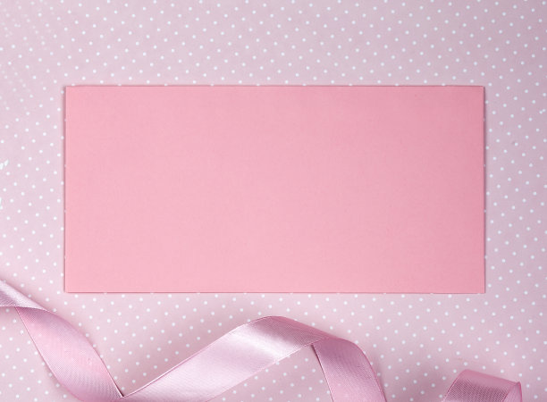 粉红色的信封和粉红色的丝带在粉红色的背景。本空间图片下载