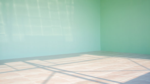 阳光和阴影在大理石瓷砖地板表面和绿色水泥墙在房屋施工现场内的空房图片下载