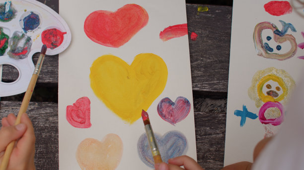 孩子们在户外用颜料画爱心。爱的信号。喷漆车间图片下载