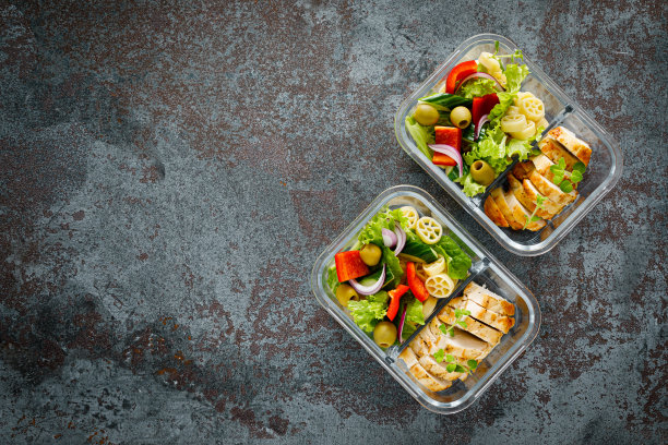 午餐盒烤鸡胸肉和意面沙拉配新鲜蔬菜。俯视图图片下载