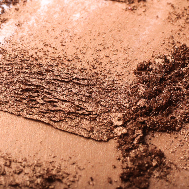 碾碎的金色眼影涂抹。摄影。专业的化妆品。抽象的化妆品的背景。图片下载