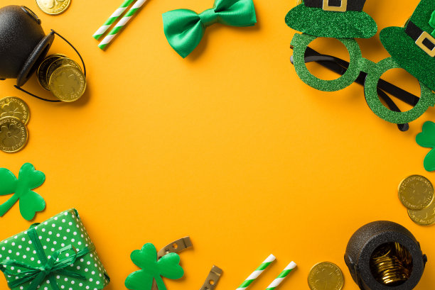 顶视图照片的圣帕特里克节装饰帽子形状的派对眼镜吸管绿色蝴蝶扣礼盒马蹄形三叶草和花盆与金币在隔离的黄色背景中间的空白图片下载