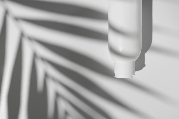 白色清洁化妆品瓶，热带棕榈叶阴影在白色背景平躺顶视图。塑料包装化妆品的品牌和标签，模拟。水疗，洗发水，乳液，保湿霜图片下载