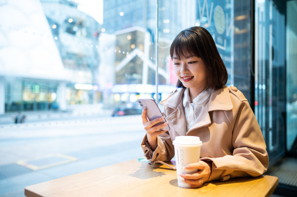 亚洲年轻女子在咖啡店使用智能手机图片下载