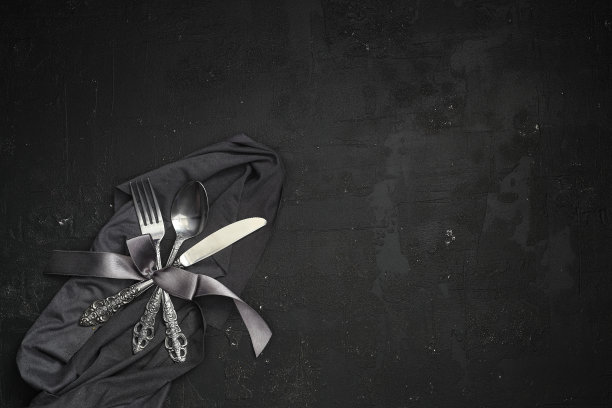 头顶上的银餐具在黑色的桌子上与复制空间。图片下载