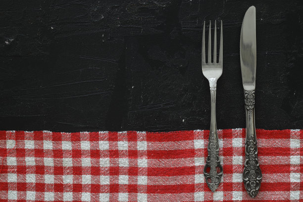 头顶上的银餐具在黑色的桌子上与复制空间。图片下载