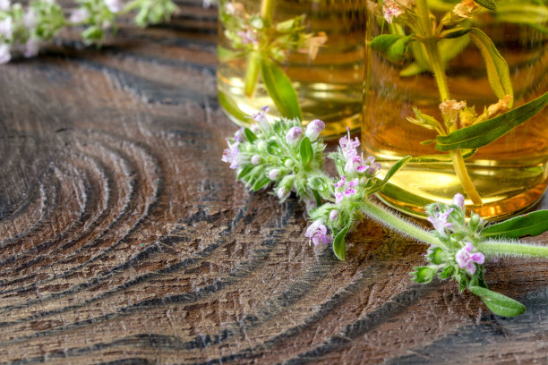 花枝百里香和玻璃瓶与精油在黑色的木制背景与复制空间为您的文本。替代医学背景图片下载
