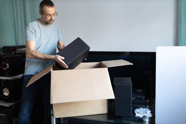 成人男子小企业主包装订购箱包装运输给客户。企业家包装盒，送货到家图片下载