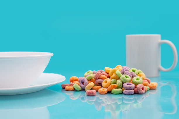 碗，杯子和彩色谷物在蓝色的背景。图片下载