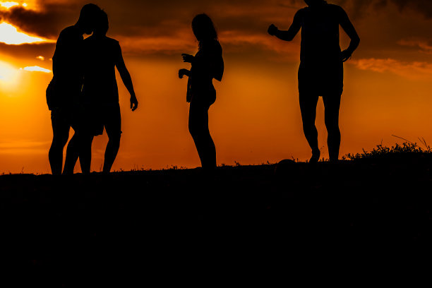 朋友们在夏天开始的时候玩沙滩足球图片下载