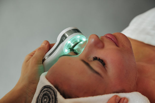 美容师在水疗中心对皮肤有问题的女性进行光疗法图片下载