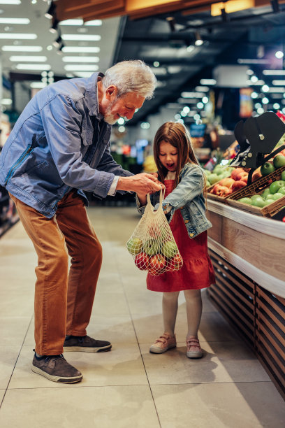 一个成熟的男人和他的孙女在杂货店购物图片下载