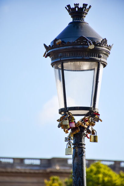 在一个阳光明媚的夏日，灯柱上挂满了婚礼钥匙锁。法国巴黎图片下载