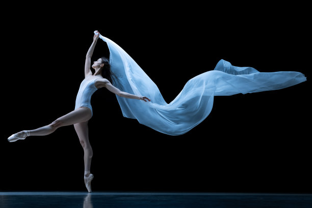 优雅的经典芭蕾舞演员跳舞与失重织物孤立在黑色霓虹灯工作室背景。戏剧，艺术，美，优雅，动作和运动的概念。图片下载