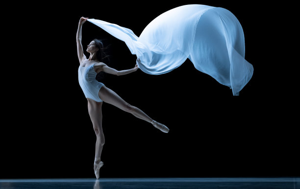 优雅的经典芭蕾舞演员跳舞与失重织物孤立在黑色霓虹灯工作室背景。戏剧，艺术，美，优雅，动作和运动的概念。图片下载
