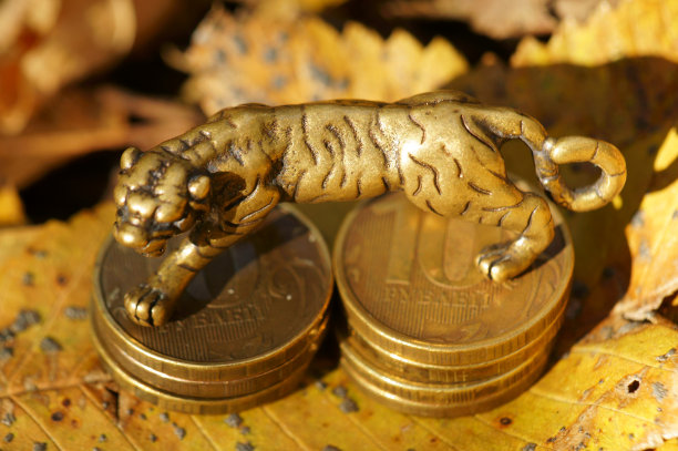 以秋叶为背景的金属老虎铜像。图片下载