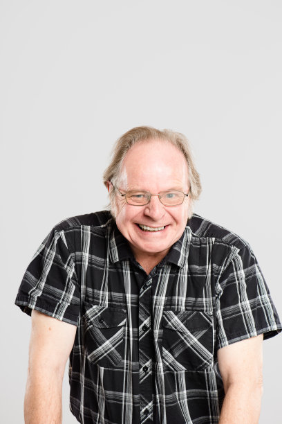 一名年长的男子独自坐在工作室里摆姿势的照片图片下载