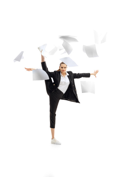 年轻美丽的女人站在一个绞线和投掷商业文件孤立在白色背景的动态肖像图片下载