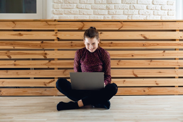 运动员的肖像与笔记本电脑在室内的在线电话和工作。在健身房里的女人图片下载