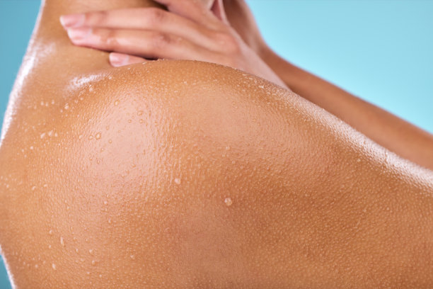 一名女子用水滴在她的皮肤上摆姿势图片下载