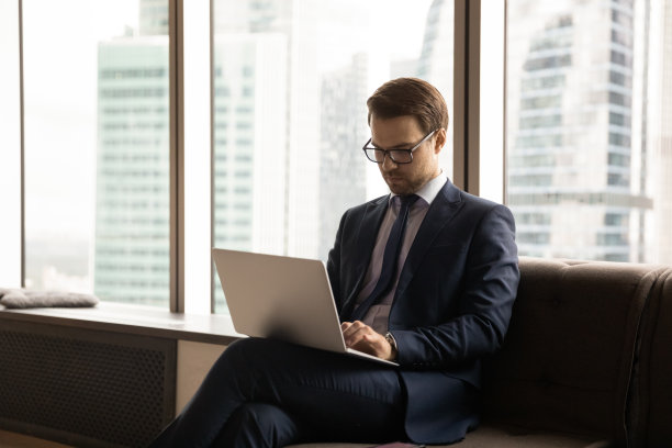 在现代化的办公室里，年轻的商人专注于电脑工作。图片下载