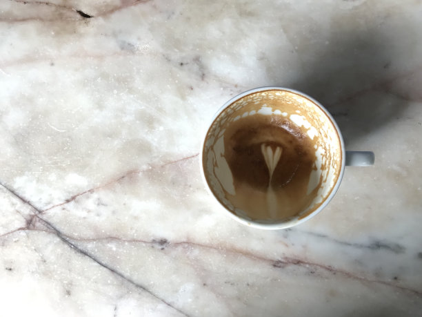 完成热拿铁咖啡在白色马克杯上时尚的大理石桌子图片下载