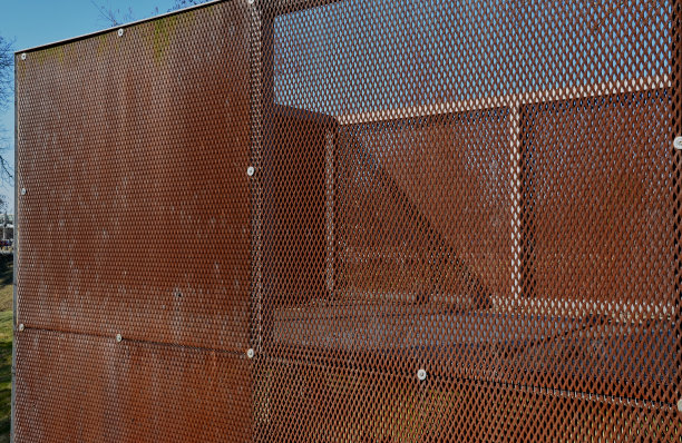 生锈的金属板栏杆由膨胀金属制成。在太空中自由飞翔。在公园里的咖啡馆附近的城市花园里，楼梯上有酒吧和低矮的栅栏。阳台阳台上有围栏图片下载