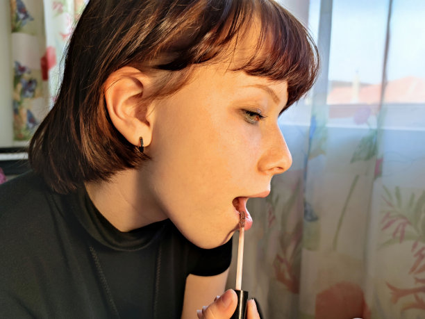 一个棕色头发的少女涂着口红图片下载