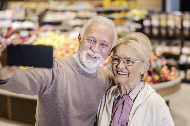 快乐的老夫妇在超市里自拍。图片下载
