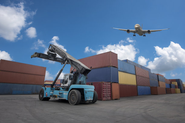 在集装箱卡车和叉车上空飞行的货机是物流业的主力。图片下载