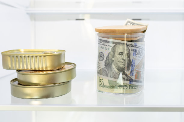 钱，现钞，美元在一个玻璃罐里，罐头食品在冰箱里。现金节约观念，影子经济，偷税漏税，糟糕的经济决策图片下载