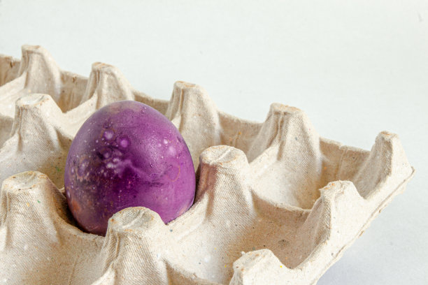 快乐的复活节假期。一个粉红色的鸡蛋放在纸板架上。图片下载