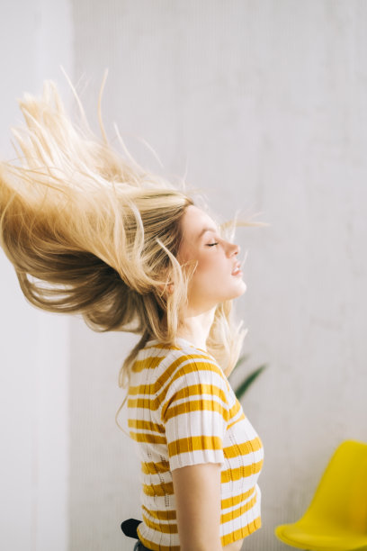 年轻迷人的白人妇女摇她的金发。图片下载