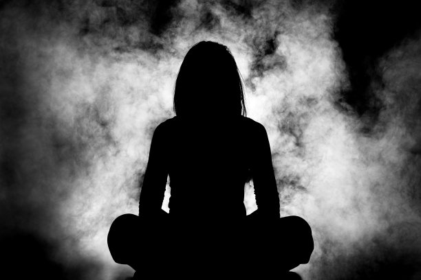 女孩坐在烟雾背景的剪影图片下载